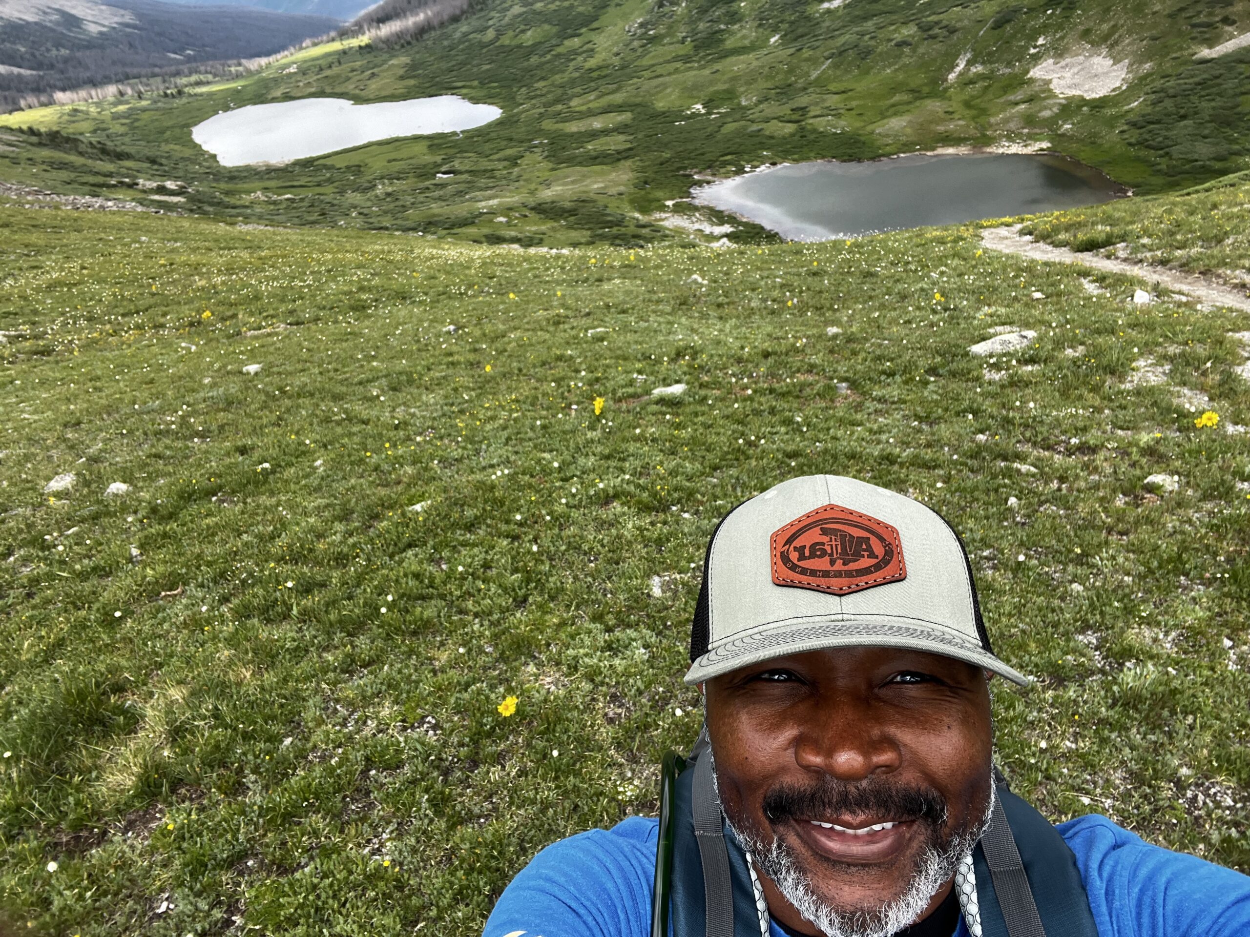 Smiling man in hat on alpine meadow Smiling man in hat on alpine meadow